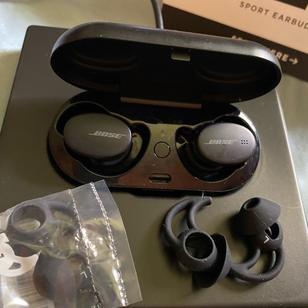 Bose sport earbuds with charger, extra ear holders, manuals.